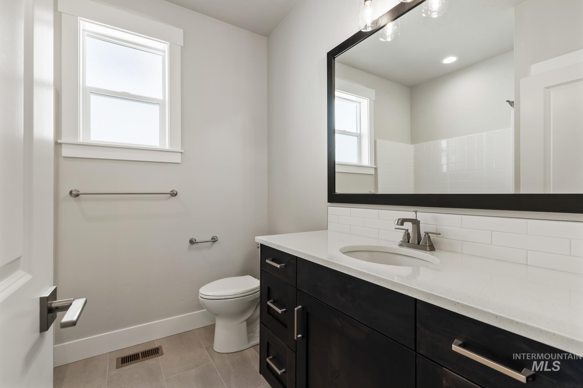 385 South Strut Way Boise, ID 83716 - Photo 10 of 30 Bathroom featuring vanity, a shower, light tile patterned floors, and recessed lighting