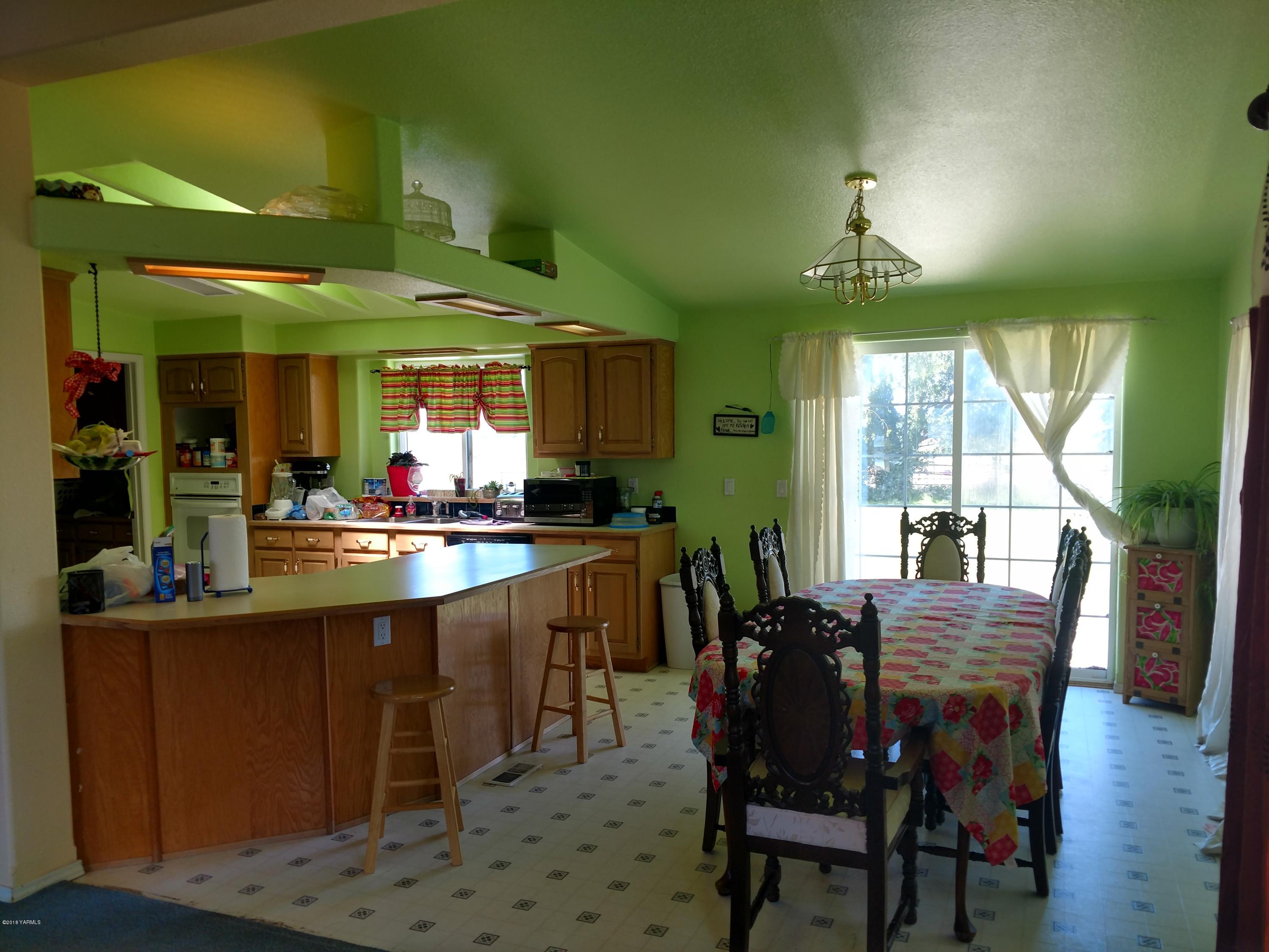 1101 Gap Road Granger, WA 98932 - Photo 13 of 24 a kitchen with stainless steel appliances kitchen island granite countertop a table and chairs in it