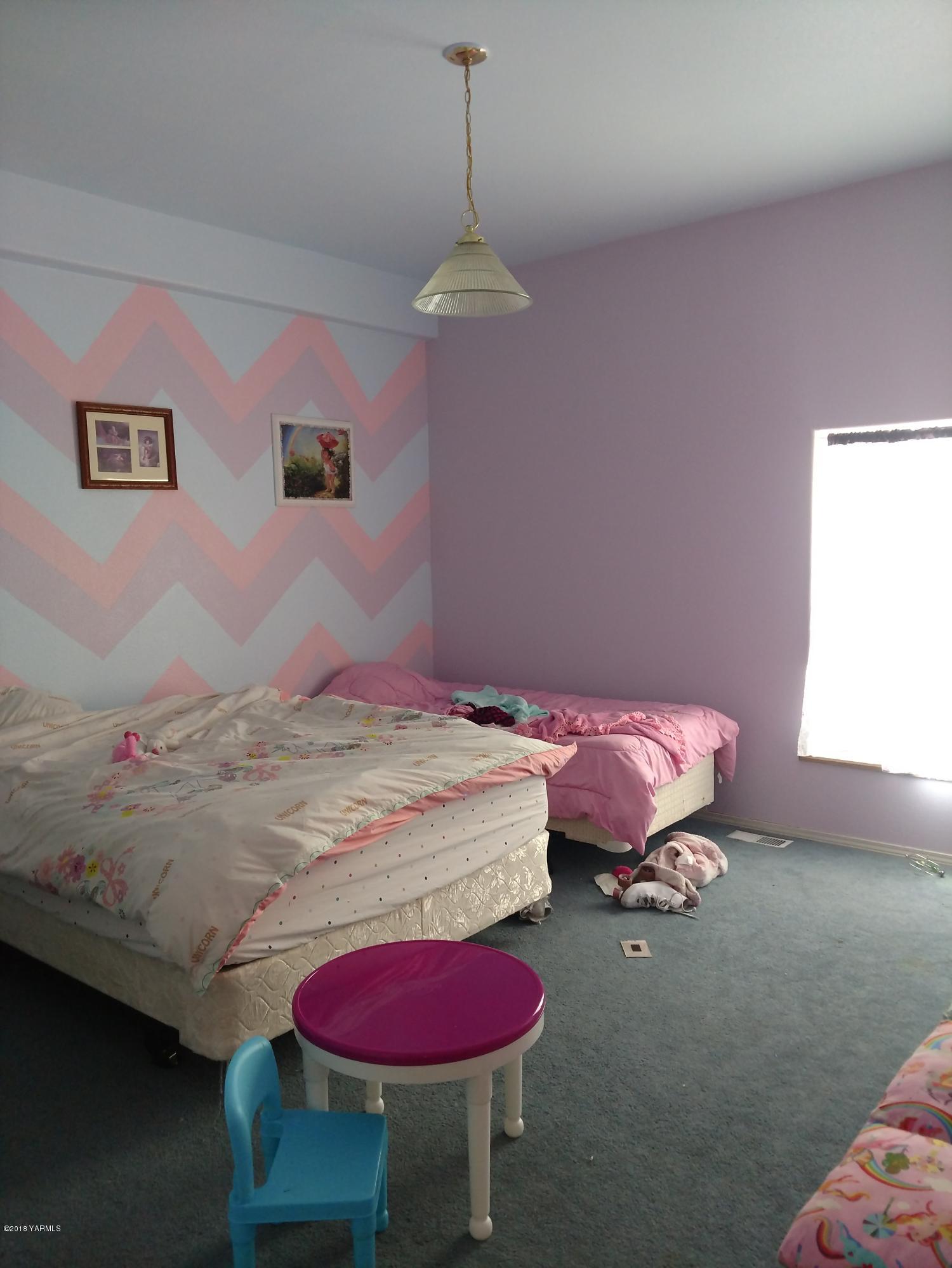 1101 Gap Road Granger, WA 98932 - Photo 23 of 24 a bedroom with a bed and a chandelier