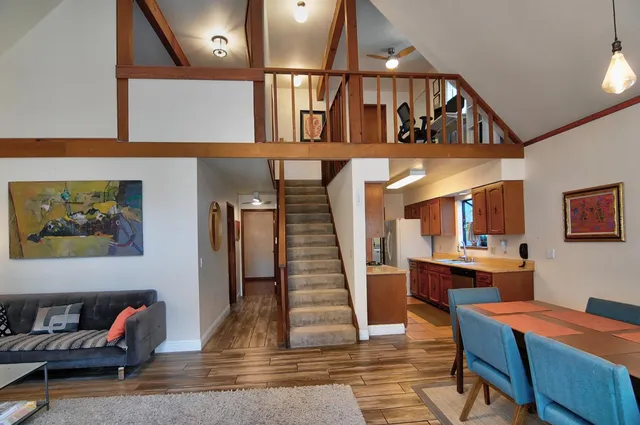 a view of a livingroom with furniture a dinning room and stairs
