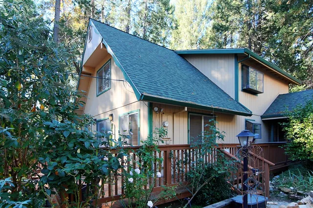 a front view of house with yard and trees around