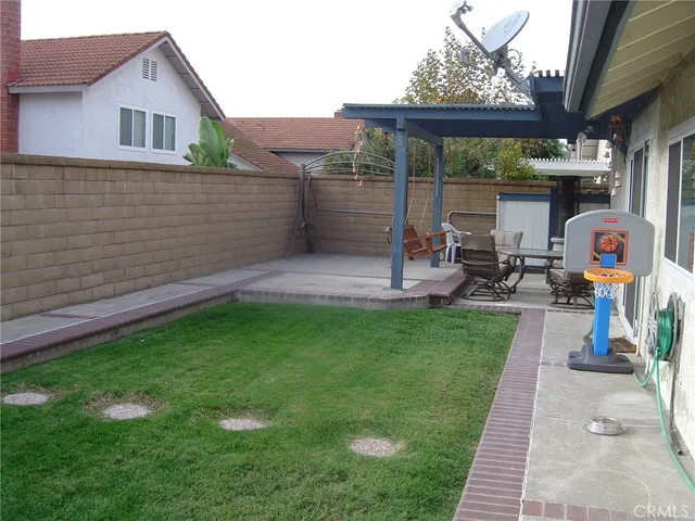 a view of a backyard with table and chairs under an umbrella