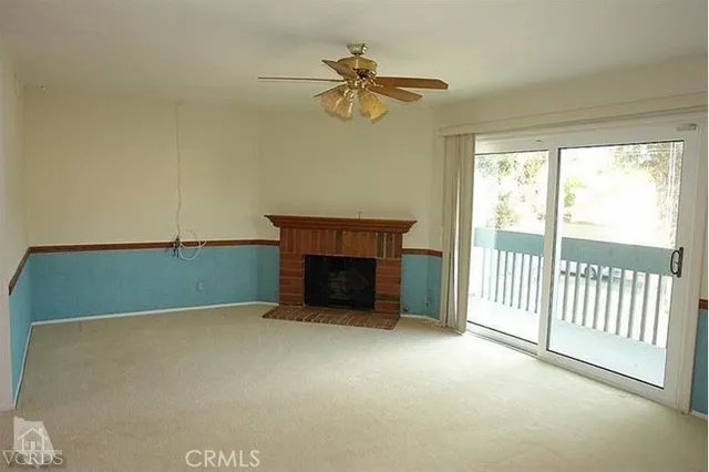 a view of a livingroom with a ceiling fan and fireplace