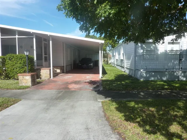 a front view of a house with a yard and potted plants