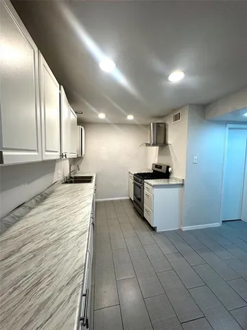 a kitchen with granite countertop a sink and cabinets