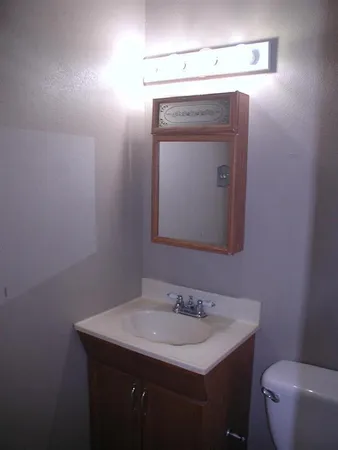 a bathroom with a toilet sink and mirror