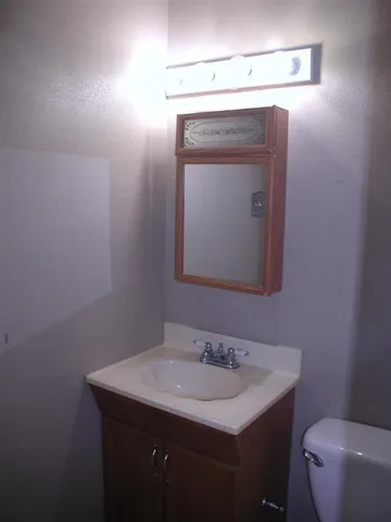 a bathroom with a toilet sink and mirror