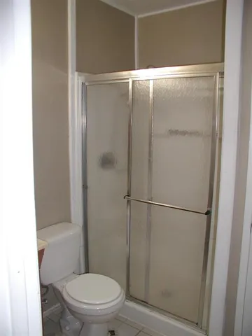 a white toilet sitting next to a shower