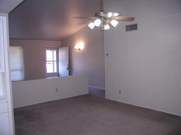 an empty room with chandelier fan