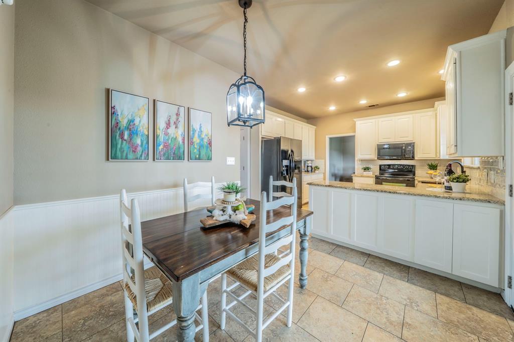 1992 Bledsoe Road Gunter, TX 75058 - Photo 13 of 40 a kitchen with stainless steel appliances kitchen island granite countertop a refrigerator a stove a sink dishwasher with a dining table and chairs