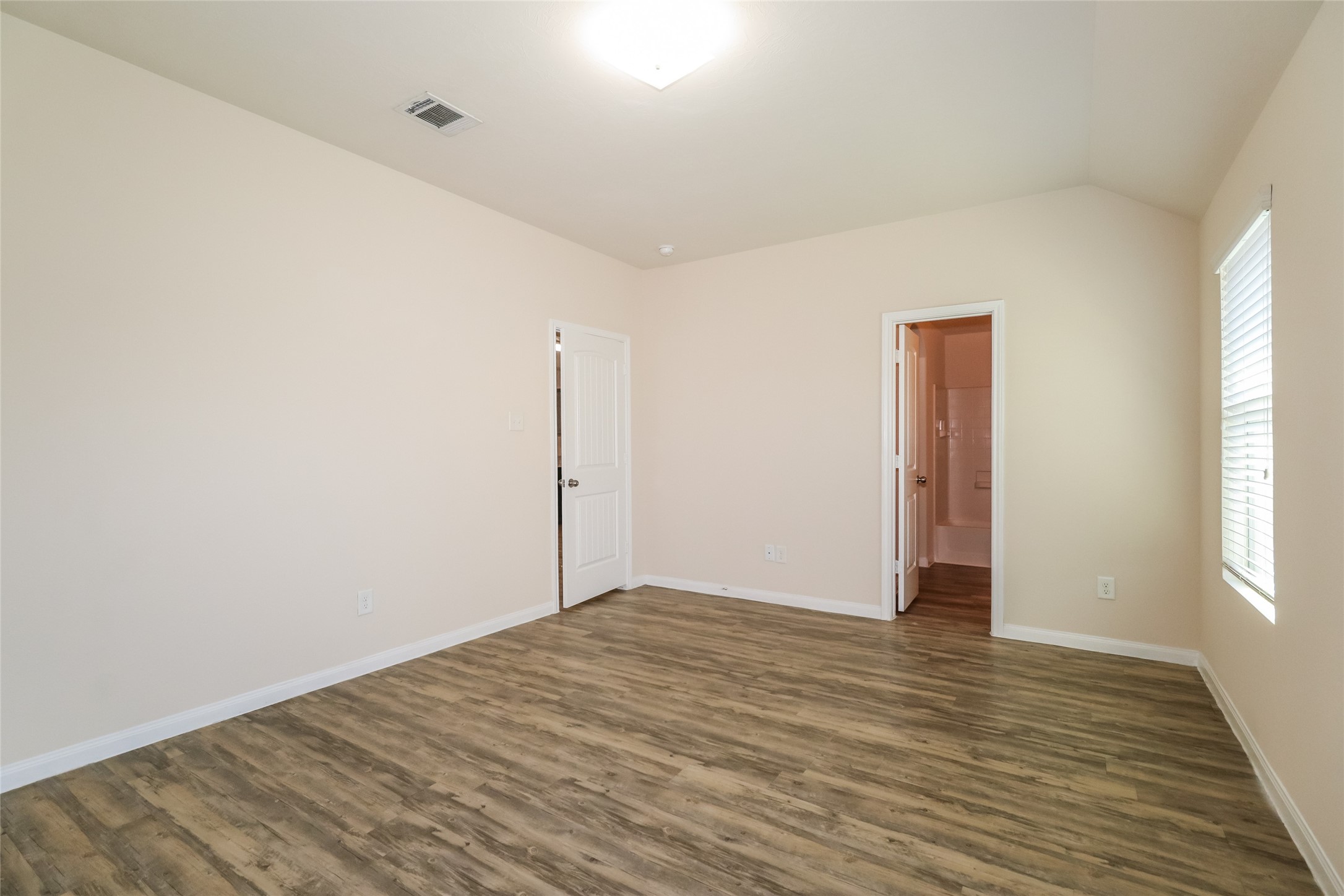 2407 Sailors Way Houston, TX 77073 - Photo 9 of 15 a view of an empty room with wooden floor and a window