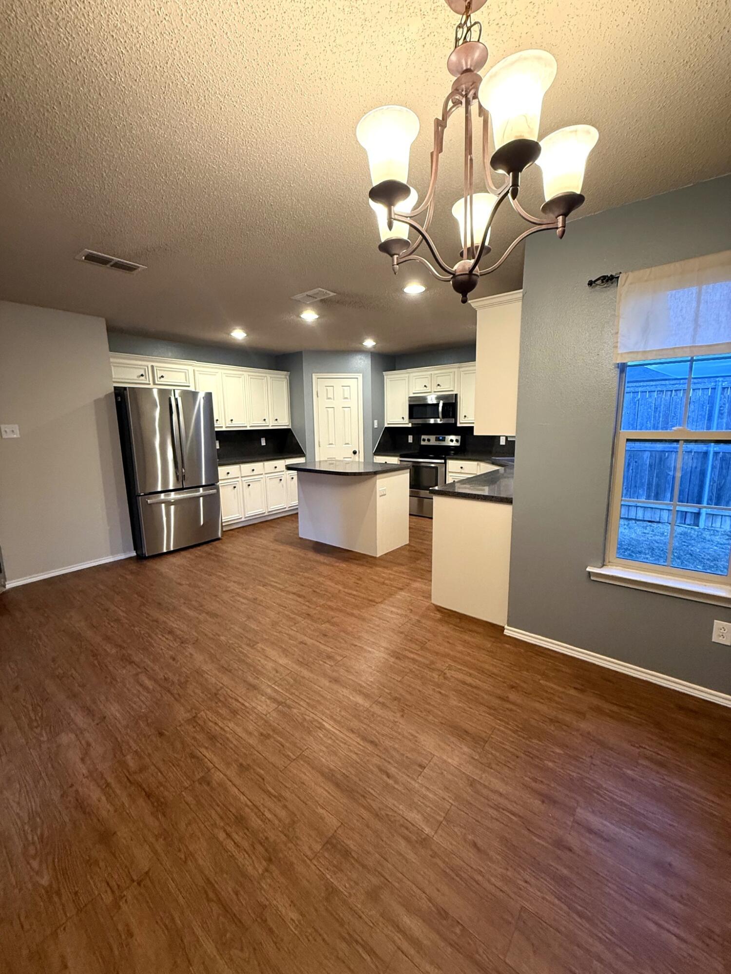 6115 100th Street Lubbock, TX 79424 - Photo 12 of 27 a kitchen with stainless steel appliances granite countertop a sink a stove and refrigerator