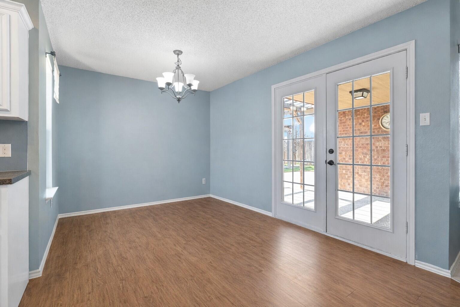 6115 100th Street Lubbock, TX 79424 - Photo 13 of 27 wooden floor in an empty room with a window
