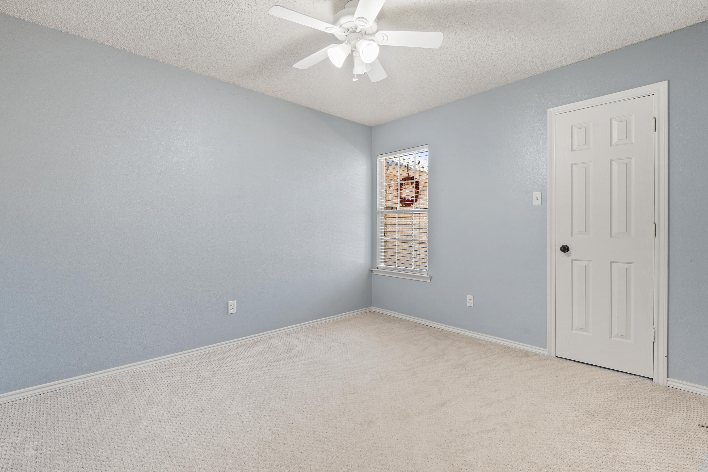 6115 100th Street Lubbock, TX 79424 - Photo 19 of 27 an empty room with windows and fan