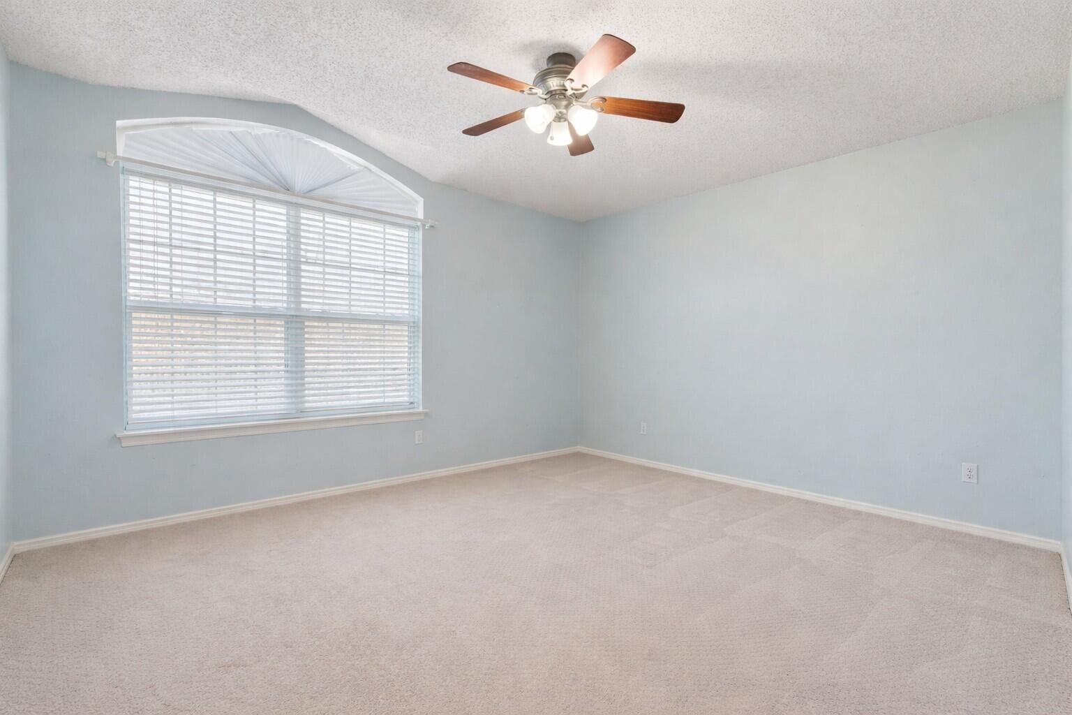 6115 100th Street Lubbock, TX 79424 - Photo 20 of 27 an empty room with windows and fan