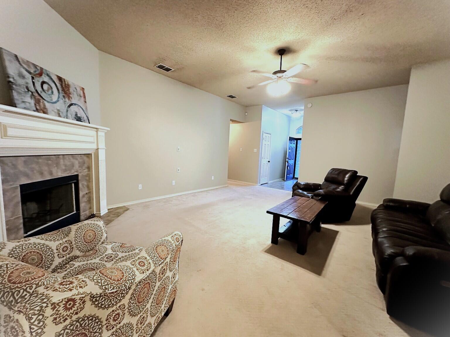 6115 100th Street Lubbock, TX 79424 - Photo 6 of 27 a living room with furniture and a fireplace