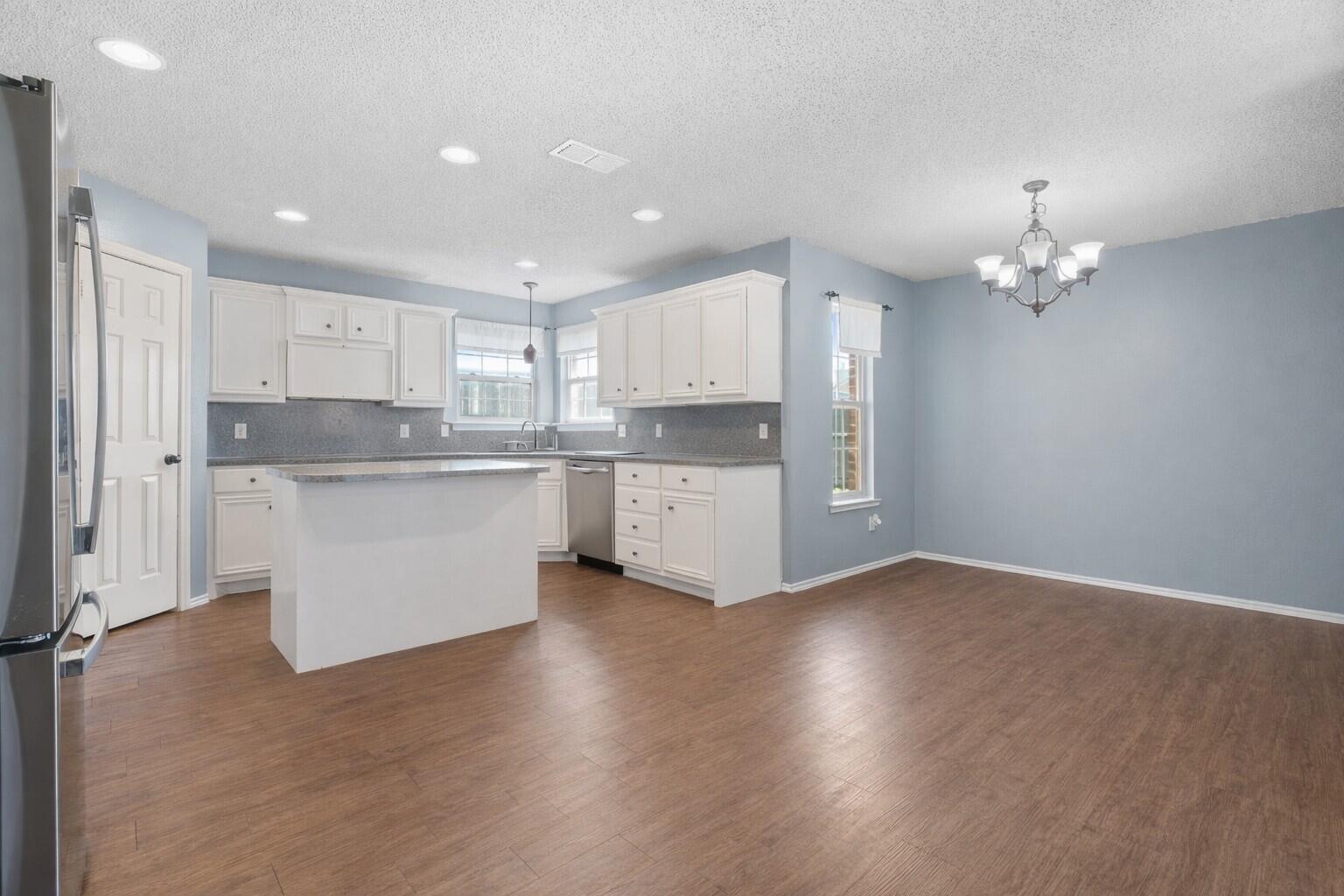 6115 100th Street Lubbock, TX 79424 - Photo 8 of 27 a kitchen with kitchen island a sink stainless steel appliances and cabinets