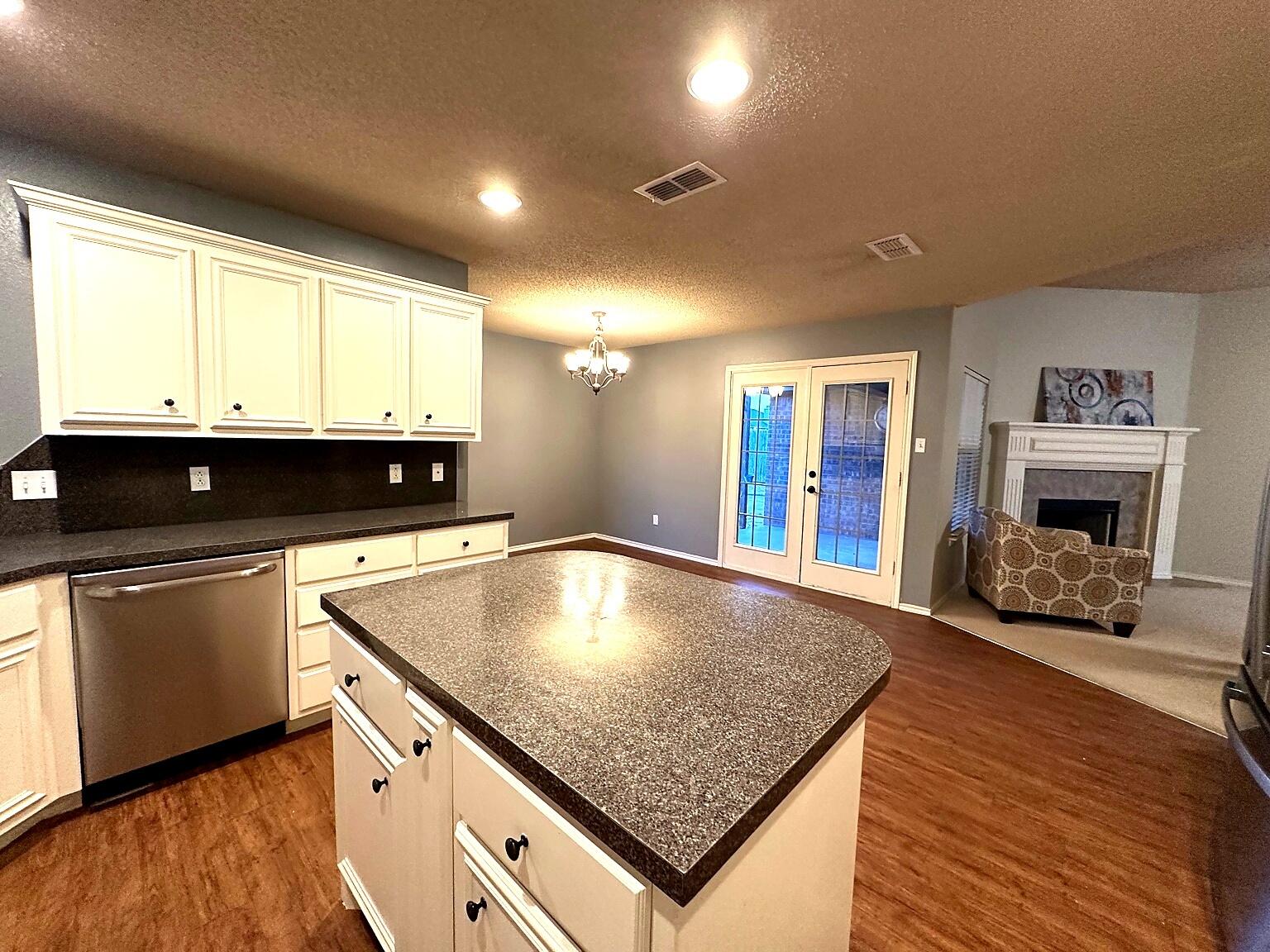 6115 100th Street Lubbock, TX 79424 - Photo 10 of 27 a kitchen with stainless steel appliances granite countertop a sink window and cabinets