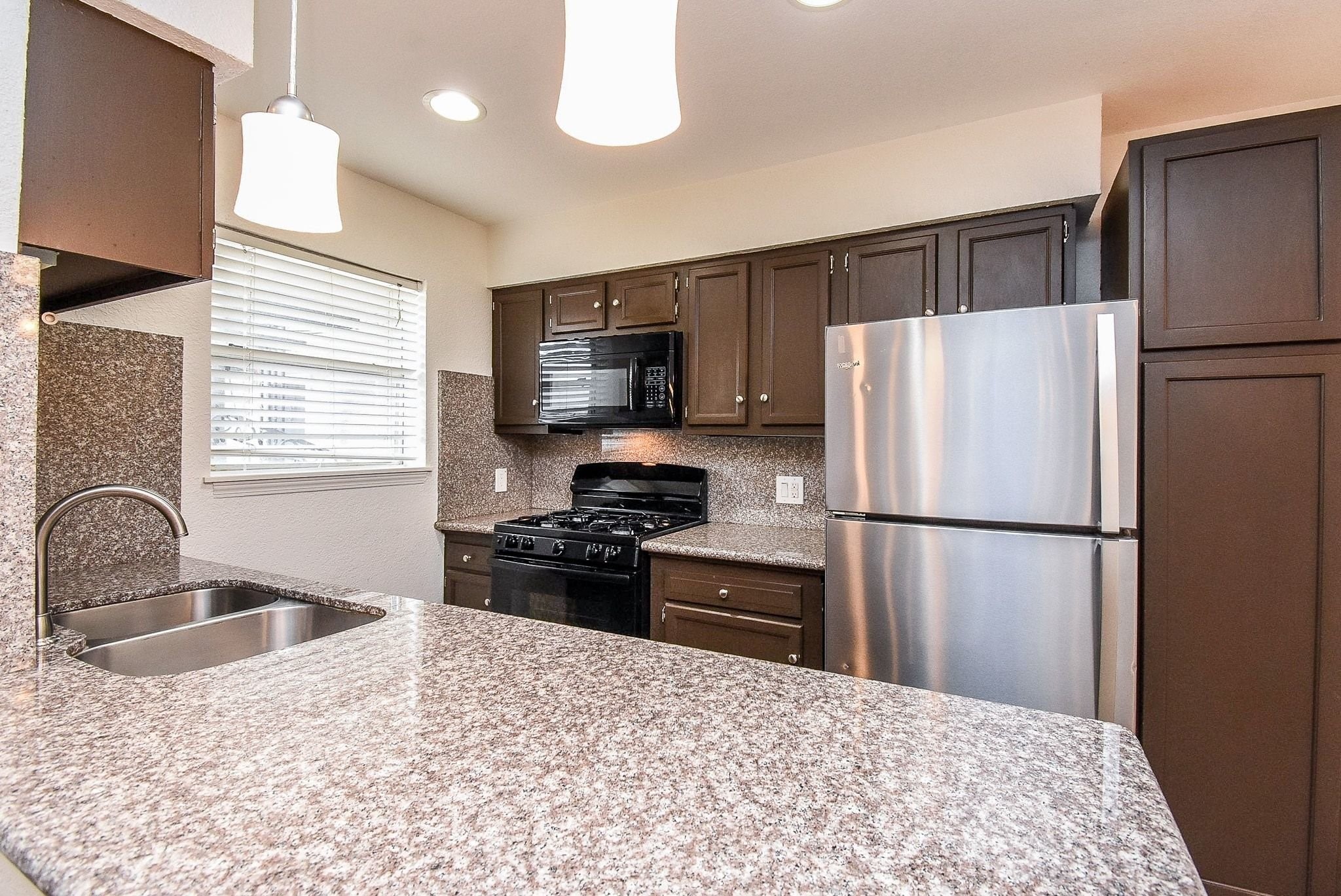 1404 Welch Street, Unit 2 Houston, TX 77006 - Photo 9 of 20 Functional kitchen layout with breakfast bar seating, abundant cabinet space, and open flow into the living and dining areas.