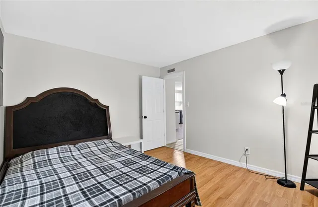 a bedroom with a bed and wooden floor