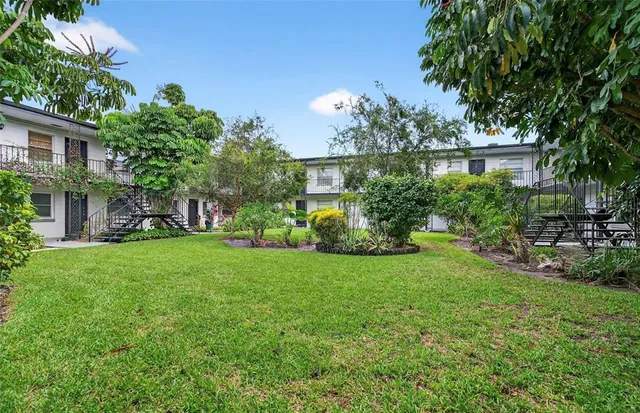 a front view of a house with a yard and tree s
