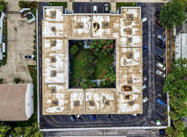 a front view of a building with glass windows and garden