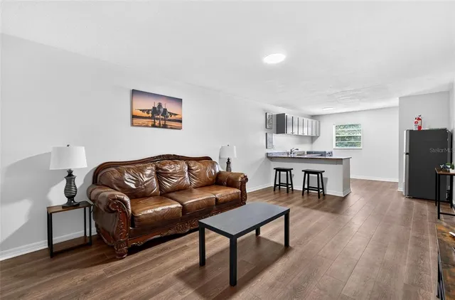 a living room with furniture and a wooden floor