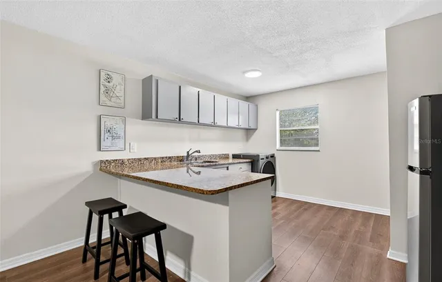 a kitchen with a sink cabinets and wooden floor