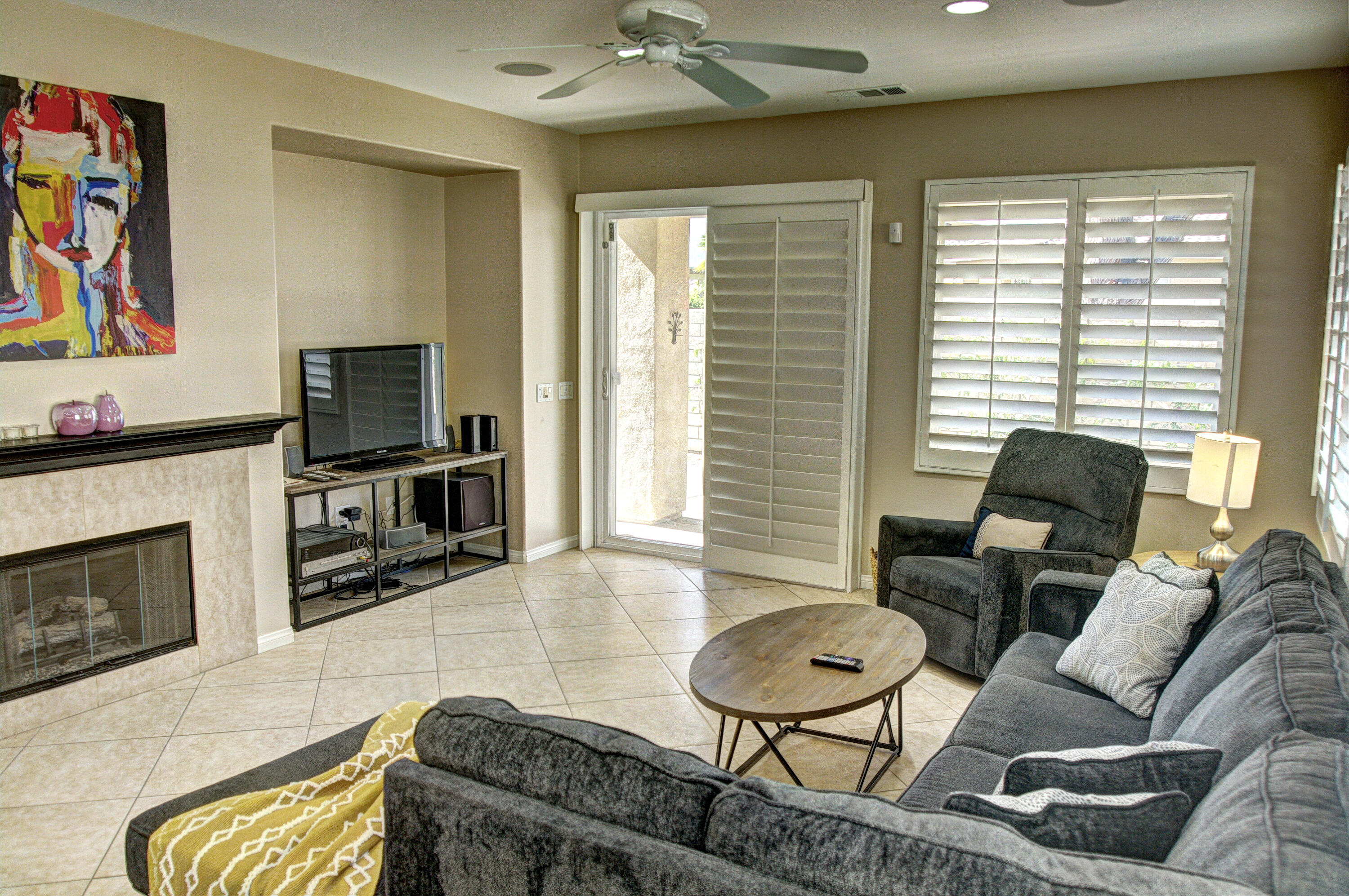 82053 Cochran Drive Indio, CA 92201 - Photo 13 of 38 a living room with furniture a flat screen tv and a fireplace
