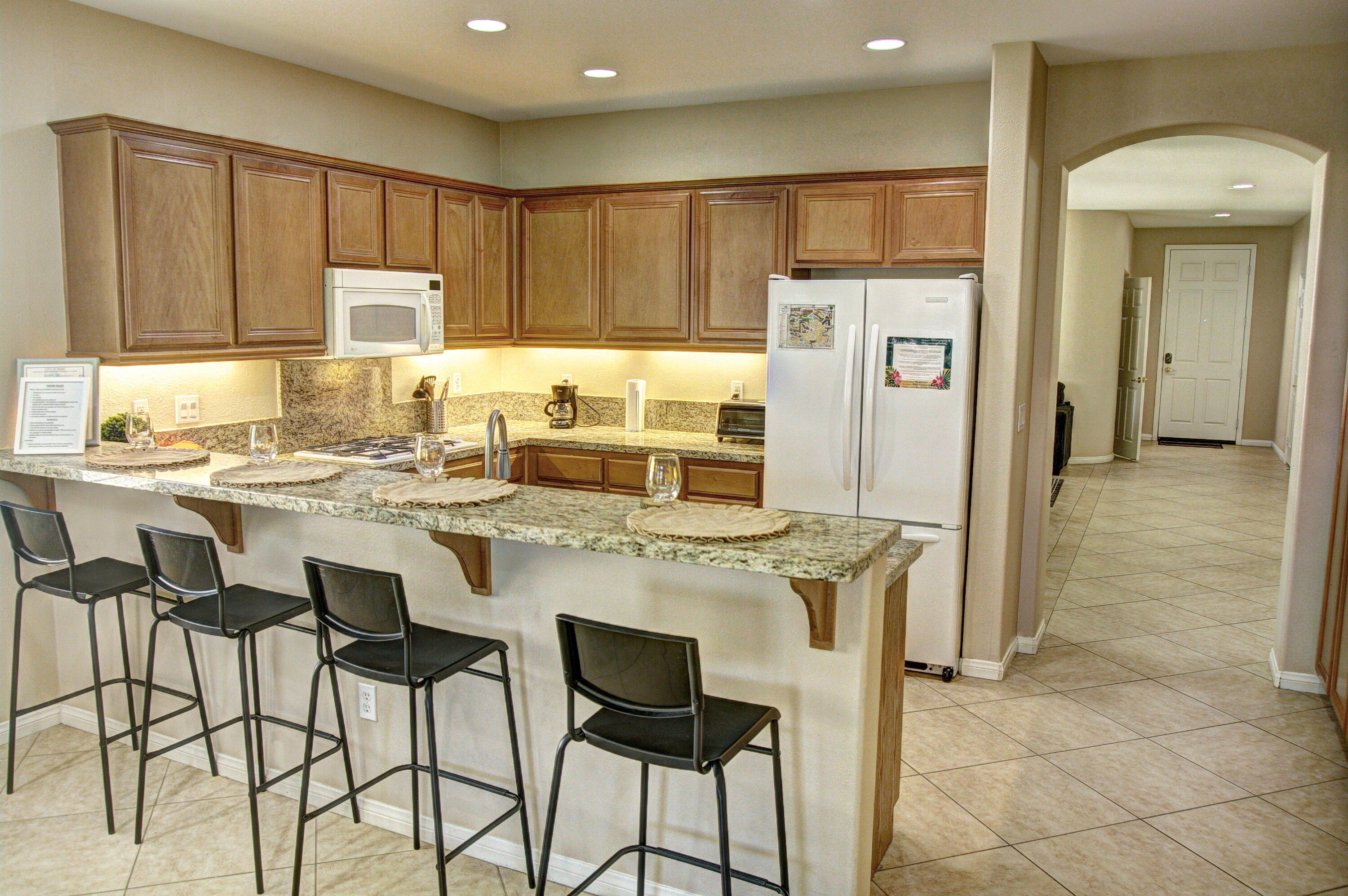 82053 Cochran Drive Indio, CA 92201 - Photo 8 of 38 a kitchen with stainless steel appliances granite countertop a stove top oven a refrigerator a sink and white cabinets with wooden floor