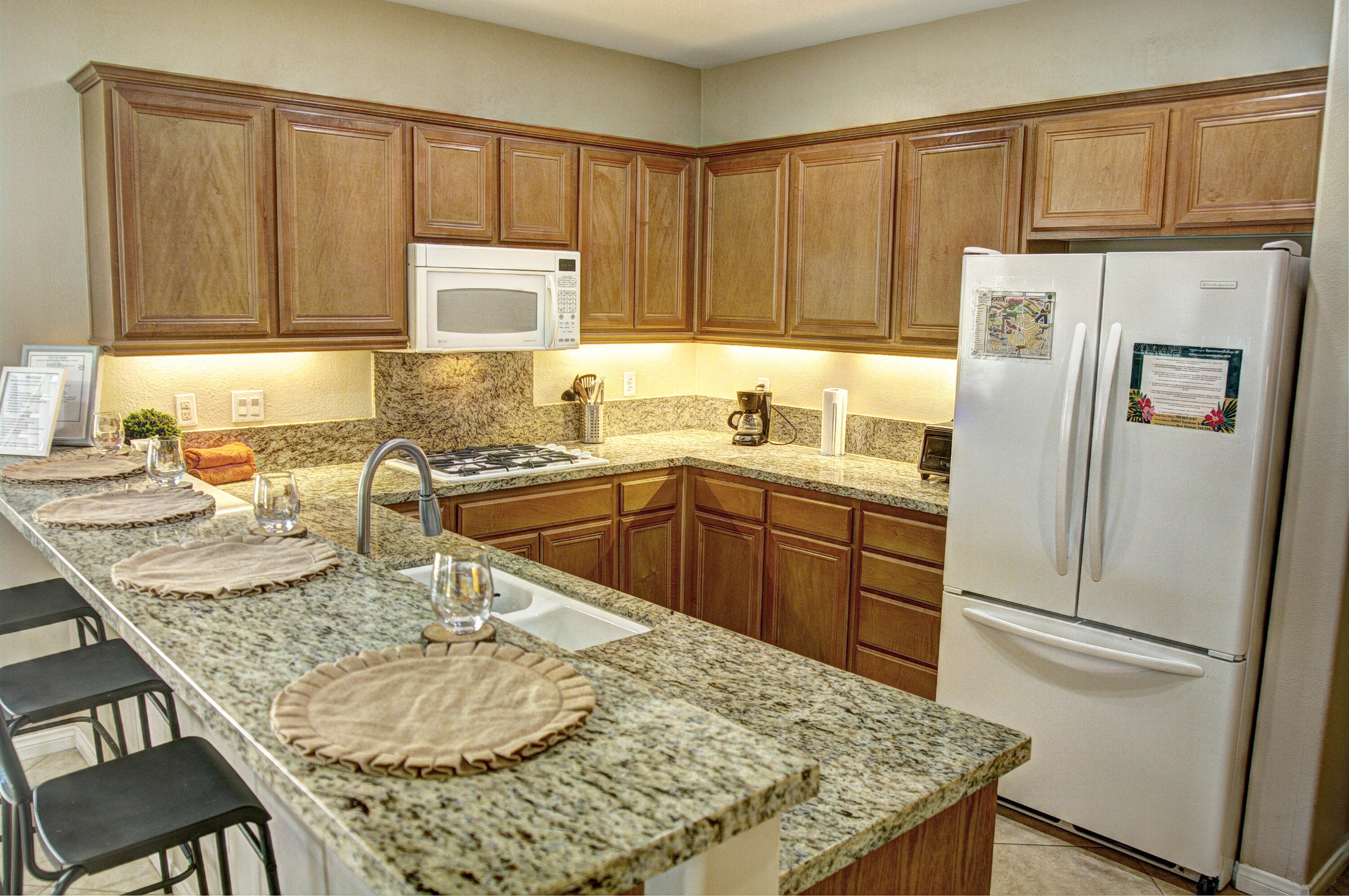 82053 Cochran Drive Indio, CA 92201 - Photo 9 of 38 a kitchen with stainless steel appliances granite countertop a sink refrigerator and cabinets