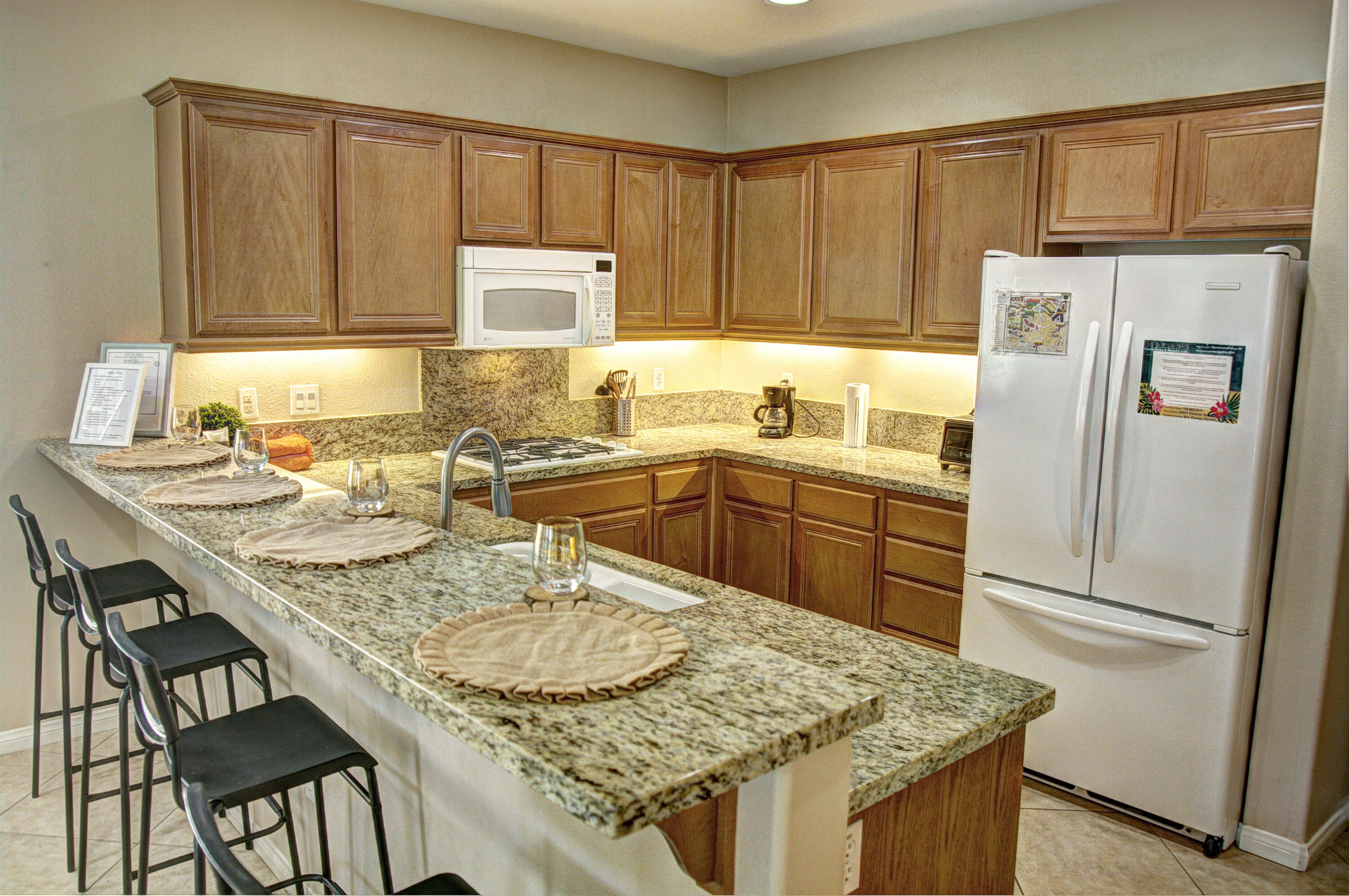 82053 Cochran Drive Indio, CA 92201 - Photo 10 of 38 a kitchen with kitchen island granite countertop a sink a stove and refrigerator