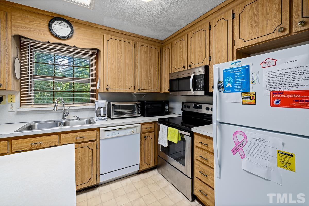 1120 Hardimont Road Raleigh, NC 27609 - Photo 6 of 24 a kitchen with stainless steel appliances granite countertop a stove a sink and a microwave