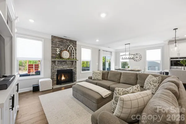 a living room with furniture a fireplace and a large window