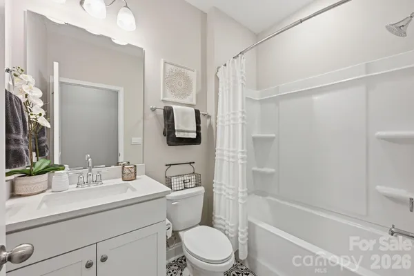 a bathroom with a sink a toilet a mirror a bathtub and shower