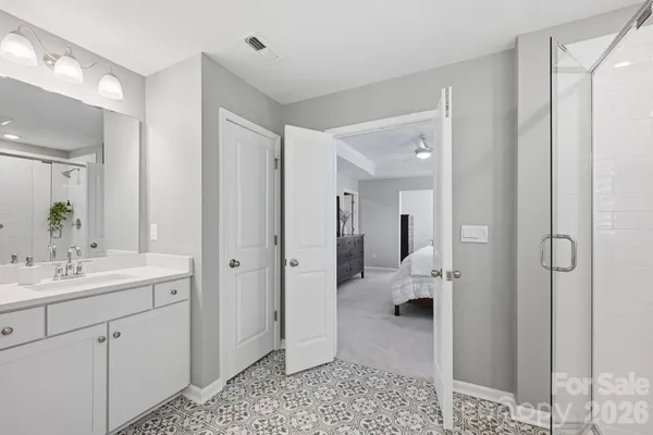 a en suite bathroom with a granite countertop sink and a mirror