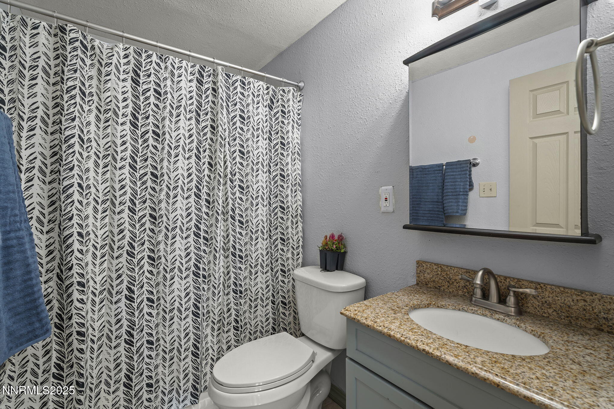 10005 Sagewood Drive Reno, NV 89506 - Photo 15 of 43 a bathroom with a granite countertop toilet sink mirror and shower