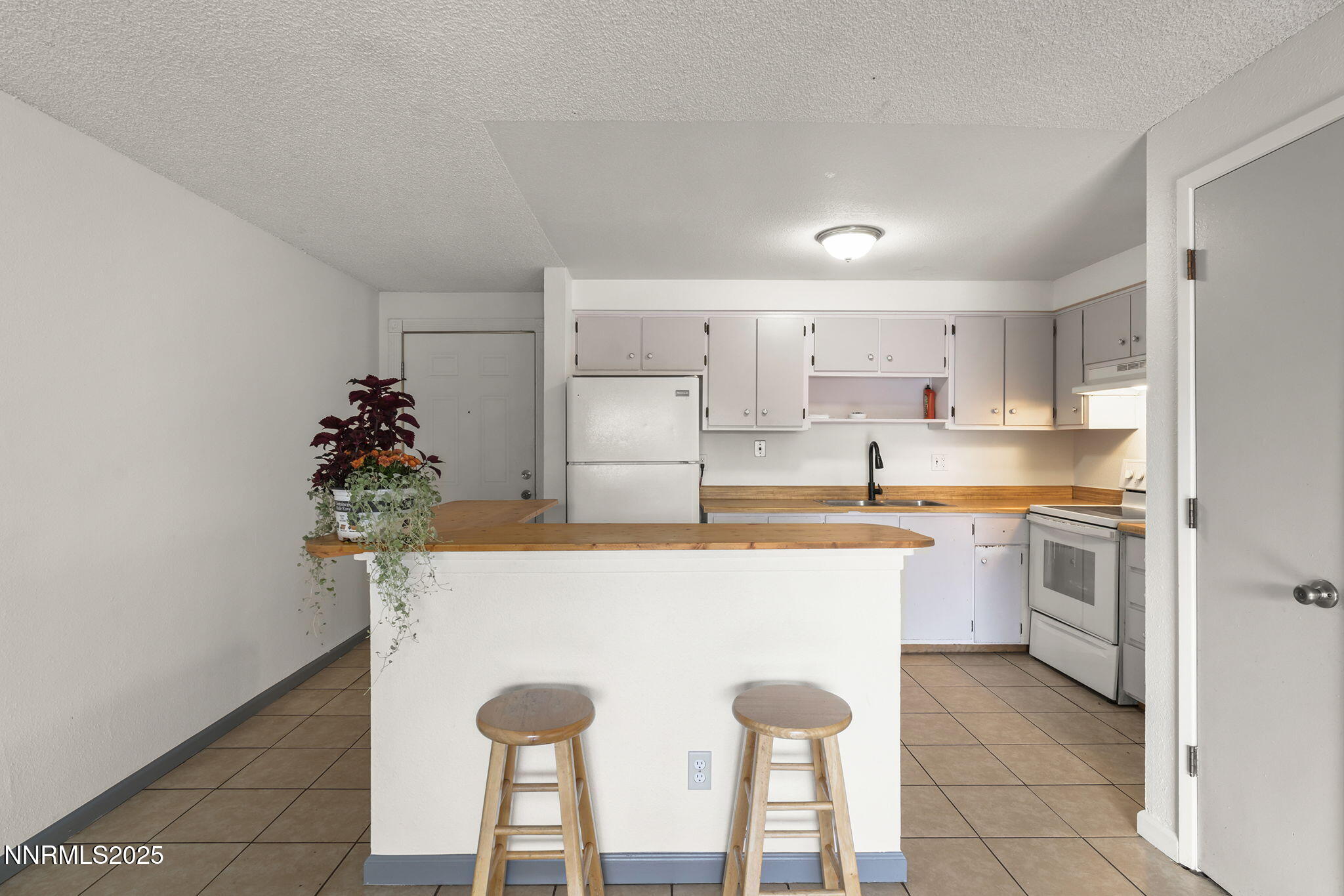 10005 Sagewood Drive Reno, NV 89506 - Photo 27 of 43 a kitchen with kitchen island a sink counter and chairs