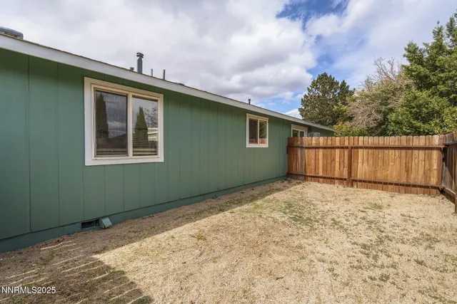 a view of a backyard with wooden fence