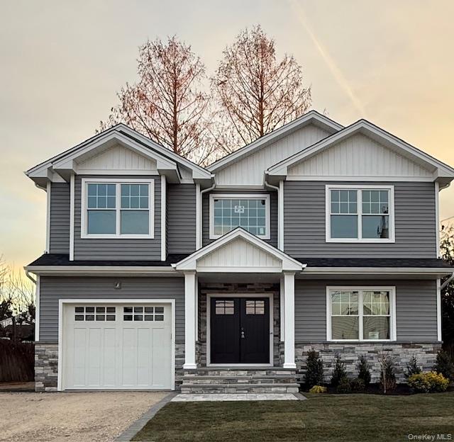 7 Greenway Circle Syosset, NY 11791 - Photo 1 of 10 Craftsman-style house featuring stone siding, a garage, driveway, and a front lawn