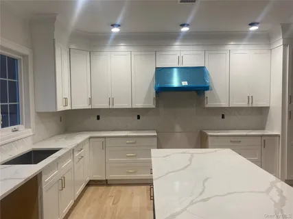 a kitchen with stainless steel appliances kitchen island granite countertop a sink a stove and cabinets