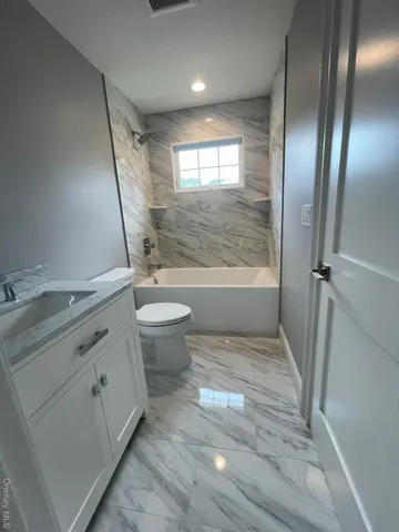 a bathroom with a granite countertop sink toilet a tub and shower
