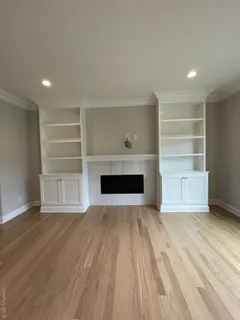 a view of empty room with wooden floor and fireplace