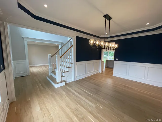 a view of a livingroom with a furniture wooden floor and chandelier