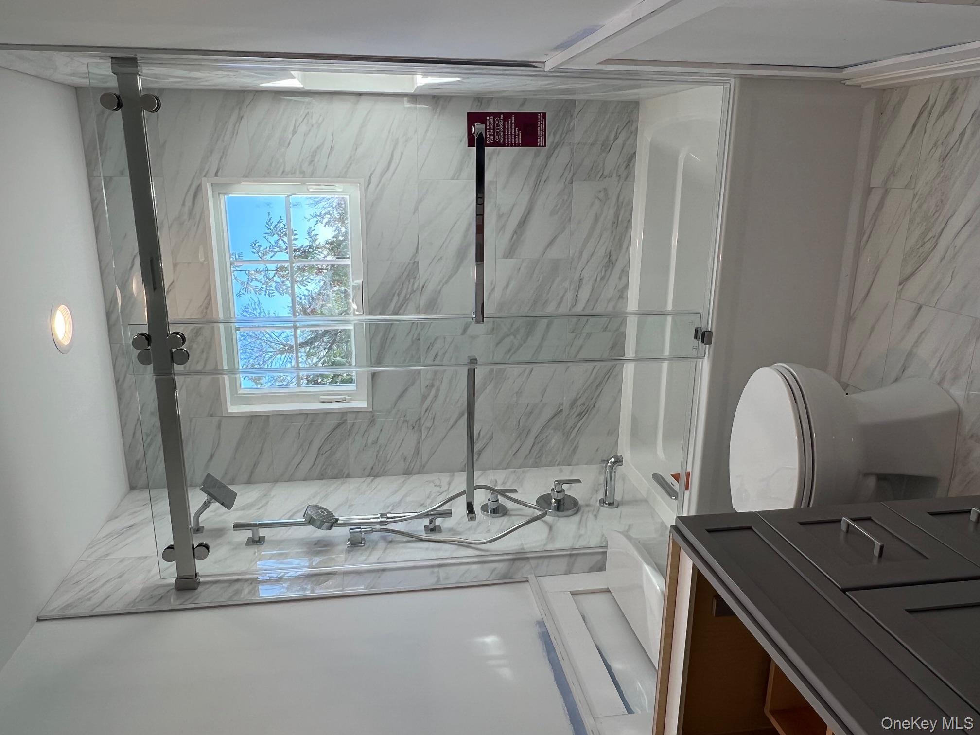 7 Greenway Circle Syosset, NY 11791 - Photo 9 of 10 Full bath featuring bath / shower combo with glass door, light marble finish flooring, and vanity