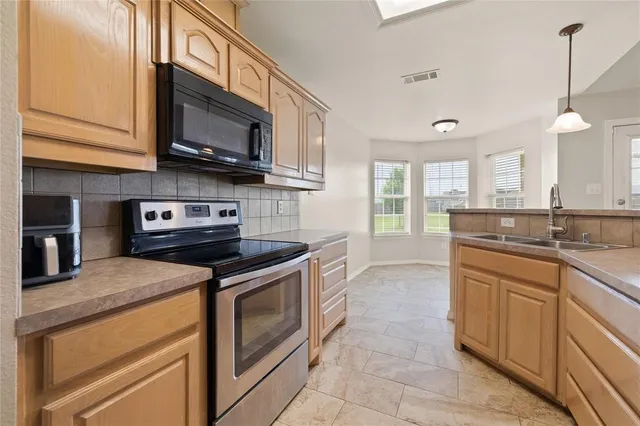 a kitchen with stainless steel appliances granite countertop a sink and a stove