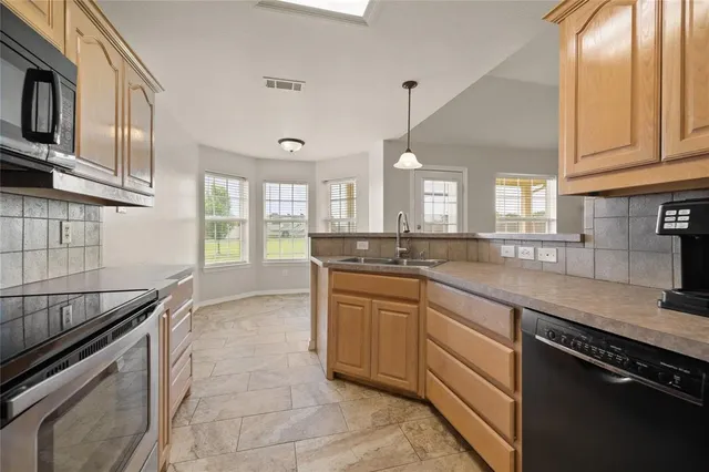 a kitchen with stainless steel appliances granite countertop a sink and stove
