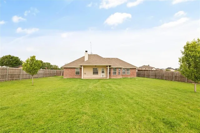 a view of a house with a yard and basketball court
