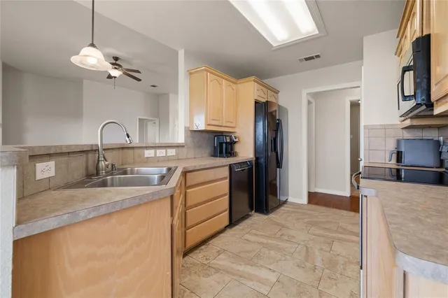 a kitchen with granite countertop a sink stainless steel appliances and cabinets