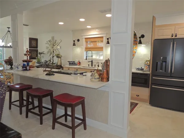 a kitchen with stainless steel appliances a refrigerator a sink dishwasher a stove and white cabinets with wooden floor